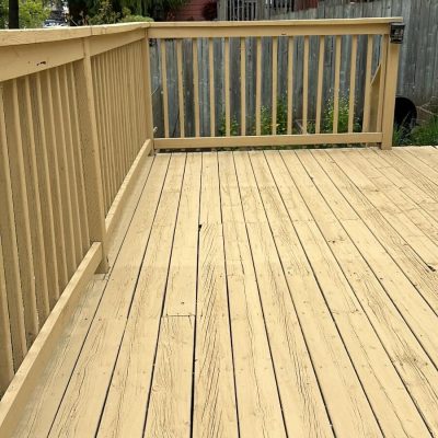 Close-up of a light-colored stained wooden deck, highlighting the smooth finish by Fit Painting's deck staining services in Kitchener-Waterloo.