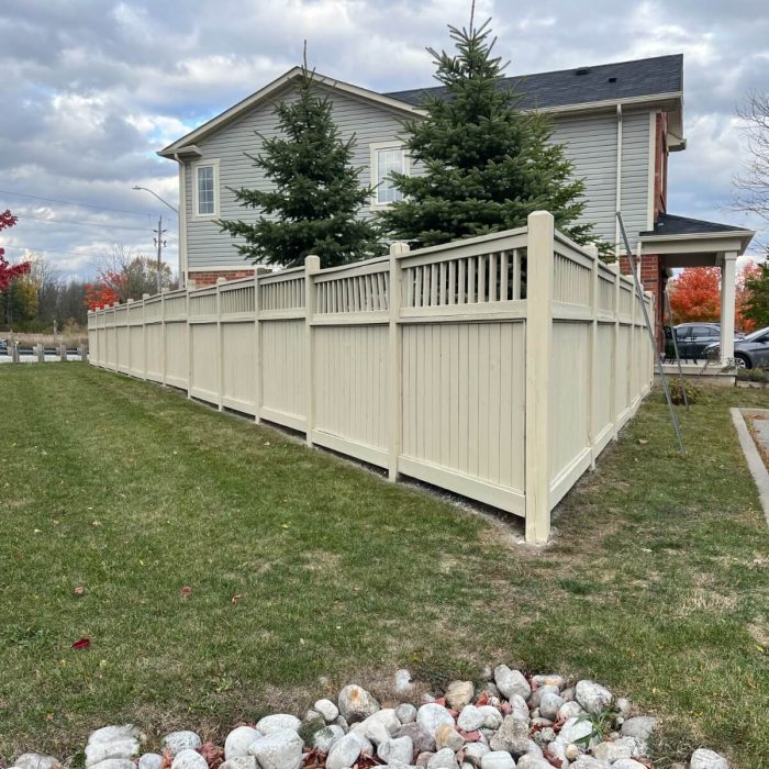 Close-up of a light-colored painted wooden fence, highlighting the smooth finish by Fit Painting's fence staining and painting services in Kitchener-Waterloo.